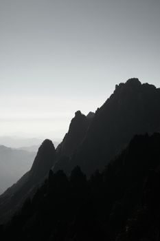 A striking black and white silhouette of rugged mountains at dusk, capturing nature's raw beauty.