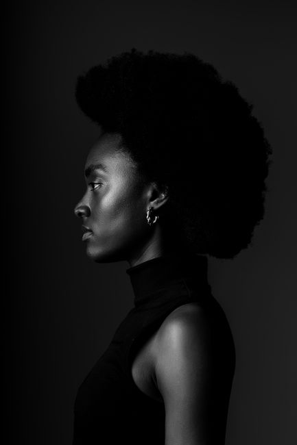 Black and white side profile portrait of an African woman with afro hairstyle.