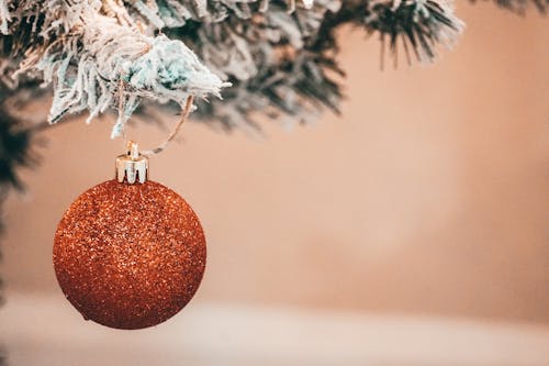 Red Glitter Bauble Hanging from Christmas Tree