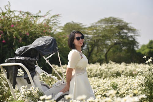 Woman in White Dress Standing in Field of White Flowers