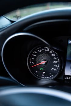 Detailed close-up of a car's speedometer and digital dashboard display, highlighting vehicle technology.