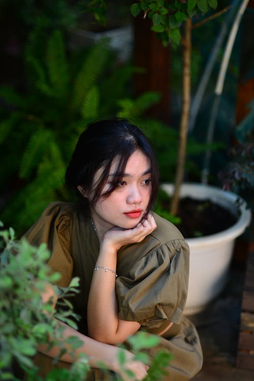 Beautiful Brunette Woman Posing by Plant