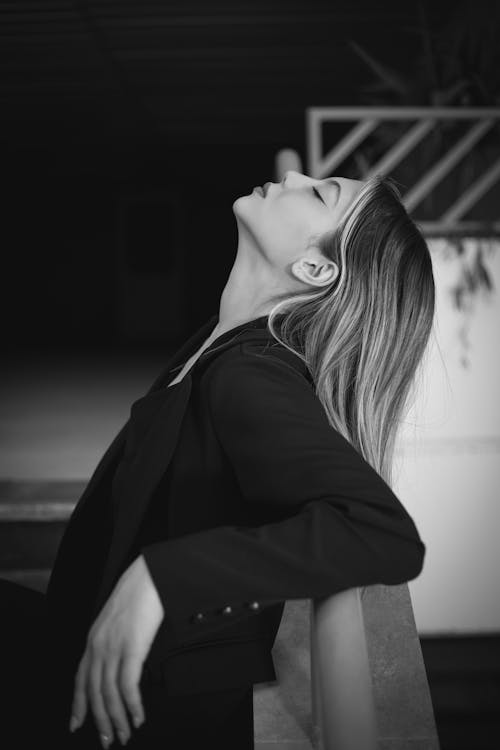 Young Woman in a Blazer Leaning Against the Railing