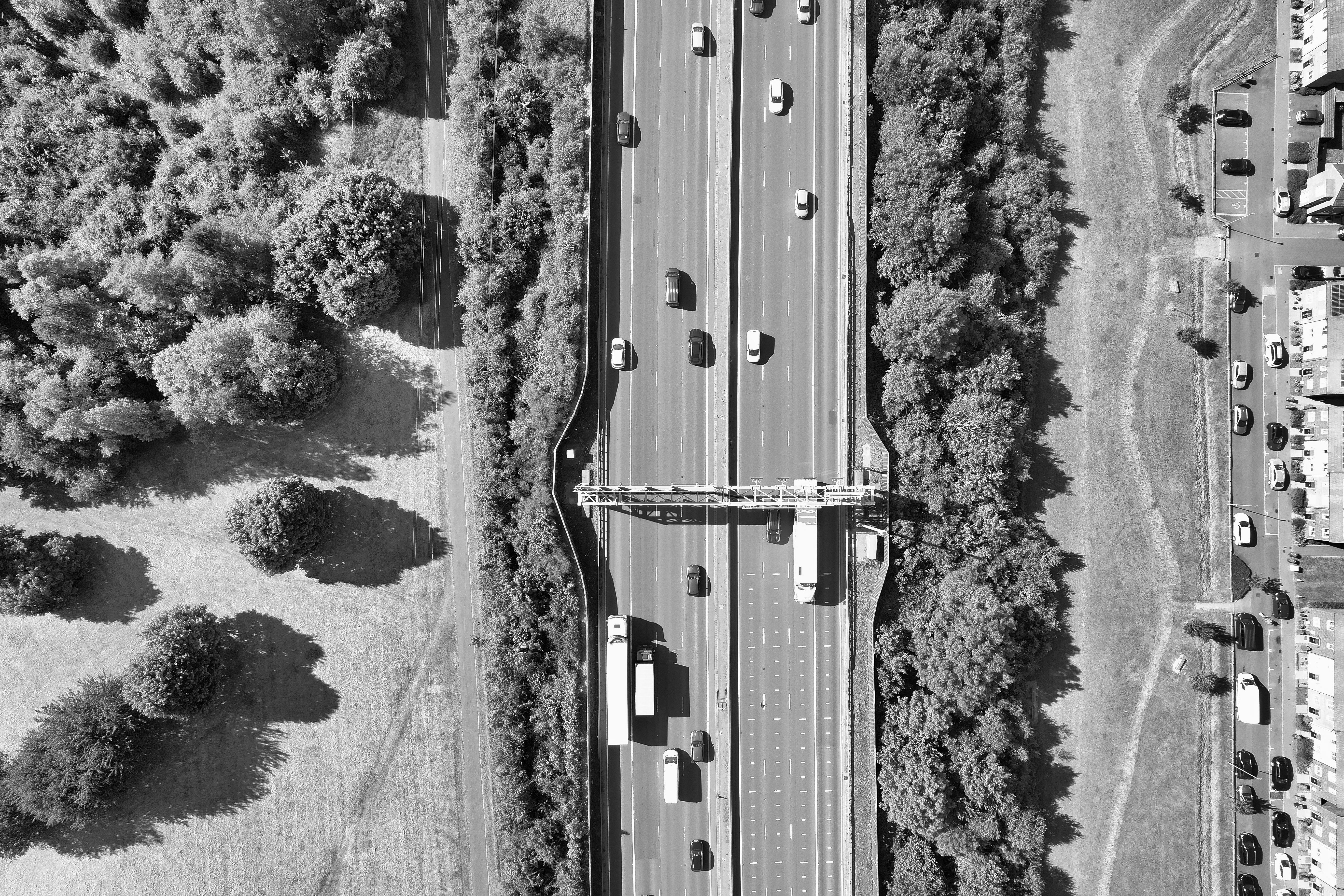 Aerial black and white photo of a busy highway surrounded by greenery in Luton, England.