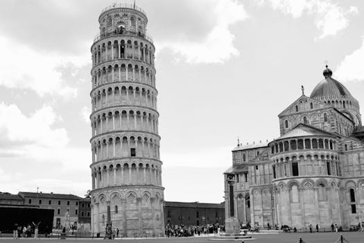 A classic black and white photo capturing the Leaning Tower of Pisa and Pisa Cathedral, Italy.