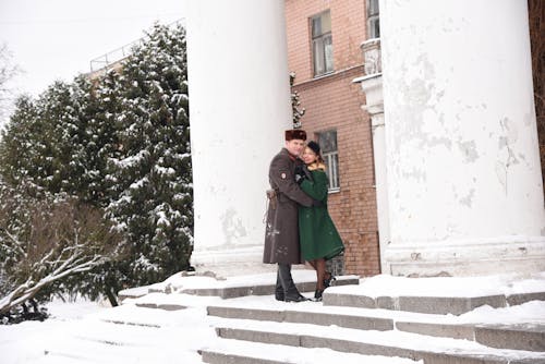Woman Hugging Russian Soldier on Stairs in Snow