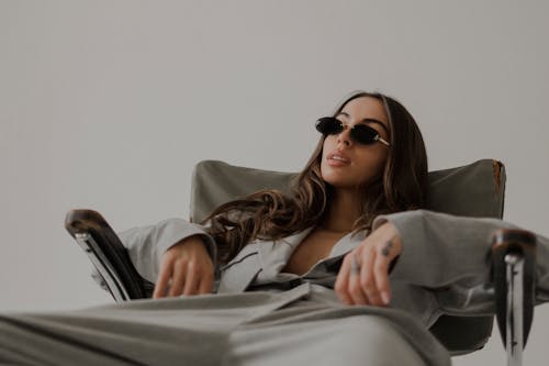 Model in a Gray Womens Suit Sprawled on an Old Ragged Chair