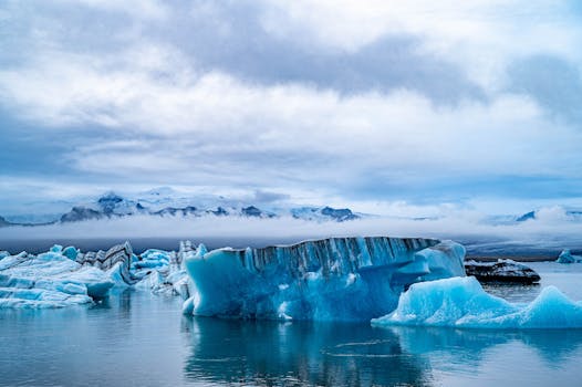 Stunning view of icebergs floating in a serene Icelandic lagoon under a cloudy sky.