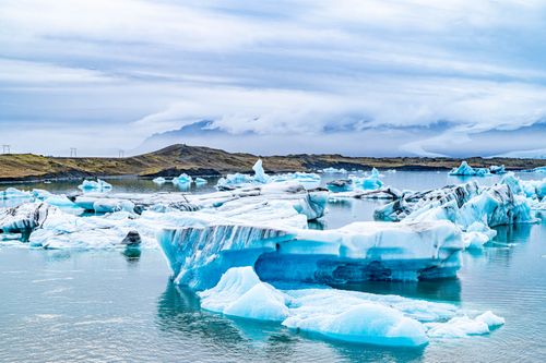 Free Breathtaking view of blue icebergs floating in Iceland's serene lagoon, under a dynamic sky. Stock Photo
