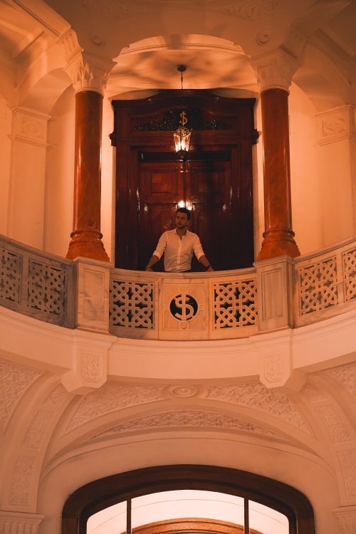 Free Man standing on an ornate balcony in a luxurious interior with columns in Ankara, Türkiye. Stock Photo