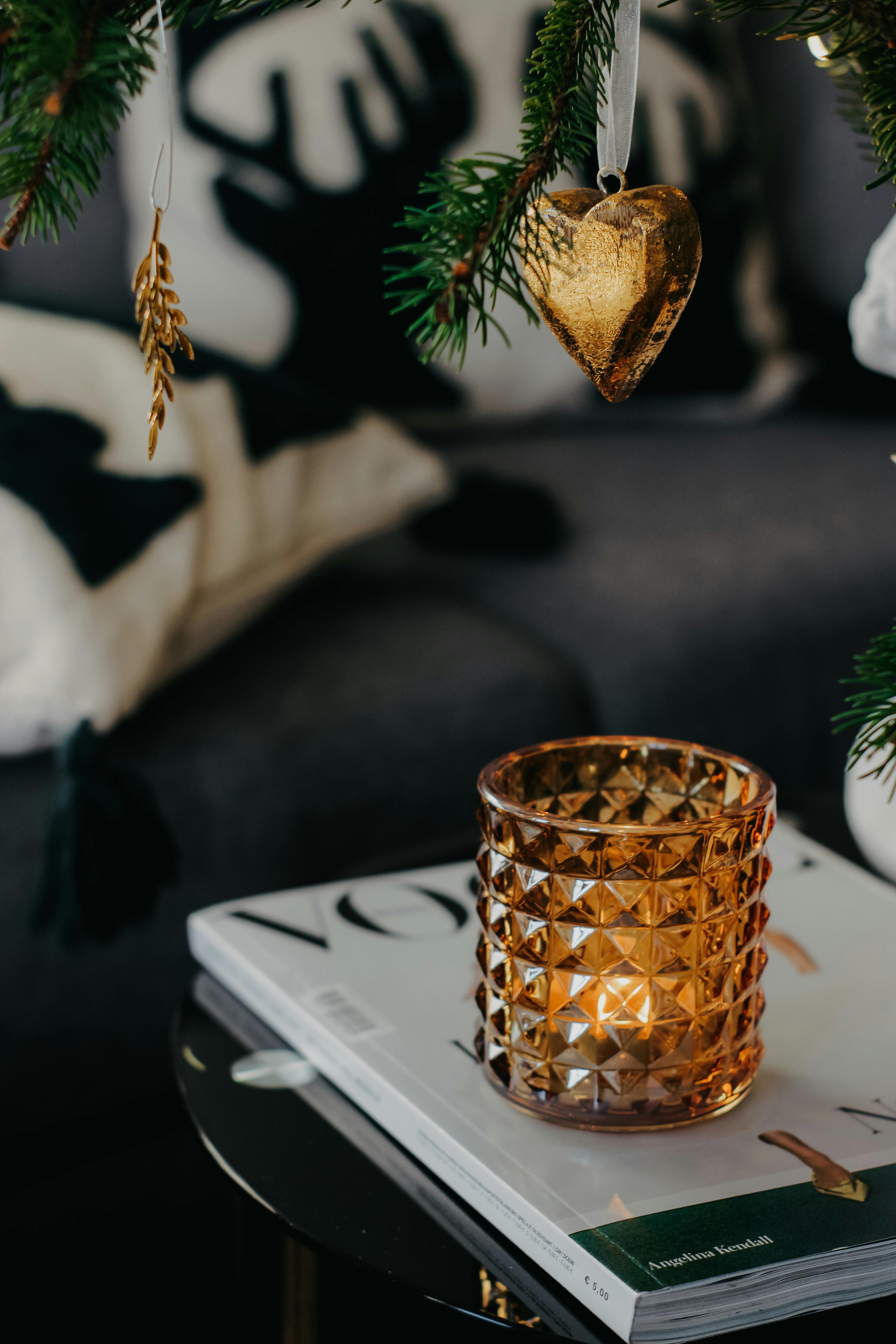 A cozy living room setup featuring a candle on a coffee table and festive Christmas decorations.