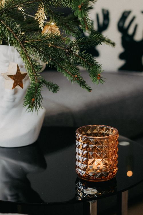 Free Warm living room scene with Christmas tree branches and candlelight creating a cozy atmosphere. Stock Photo