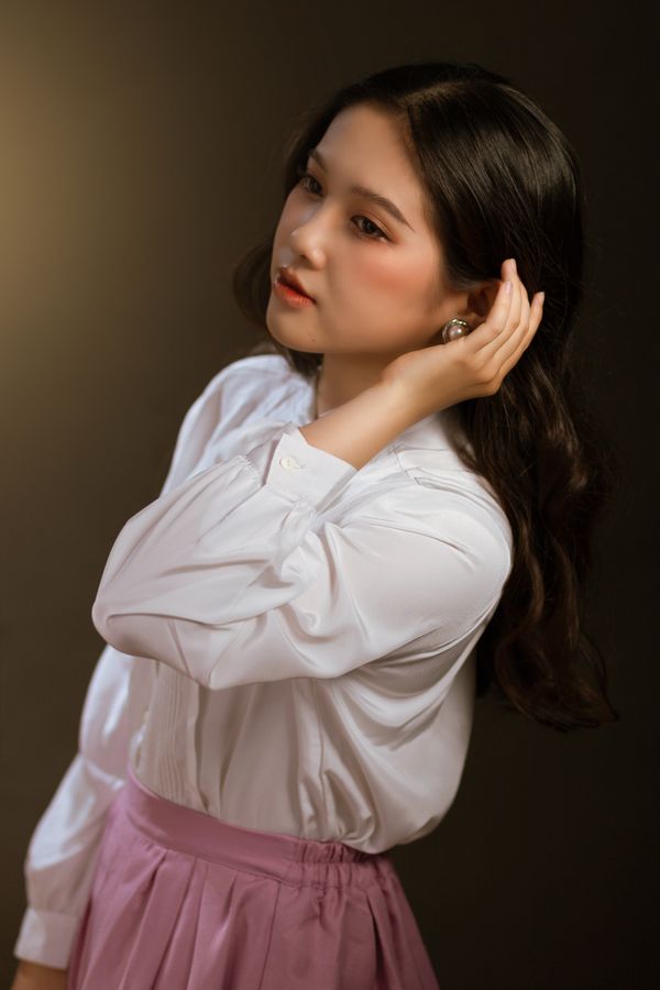 A professional woman wearing a pleated midi skirt with a silk button-down blouse