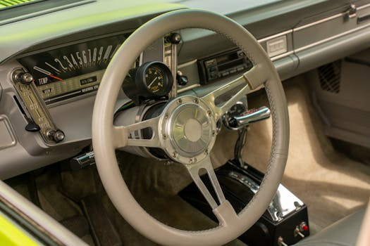 Close-up of a vintage car's interior showcasing a classic dashboard and steering wheel.