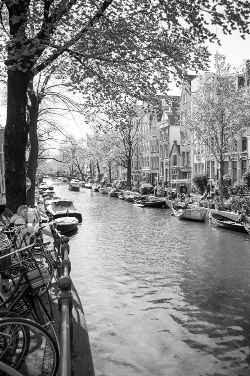 Free Charming city canal scene with moored boats and classic architecture in black and white. Stock Photo