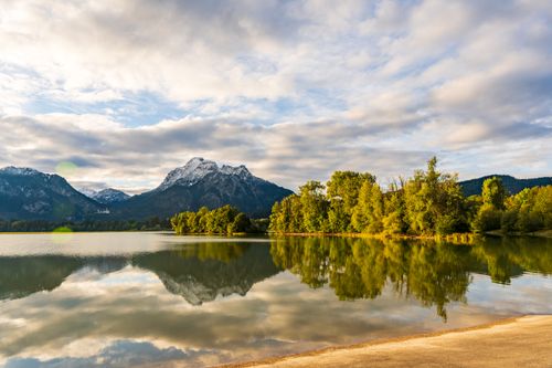 Free Tranquil scene of lake and mountains with vivid reflections under a dynamic sky in Bavaria, Germany. Stock Photo