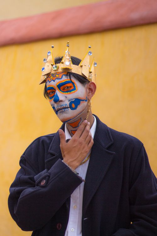 Free Man with sugar skull face painting and crown, celebrating Mexican tradition. Stock Photo