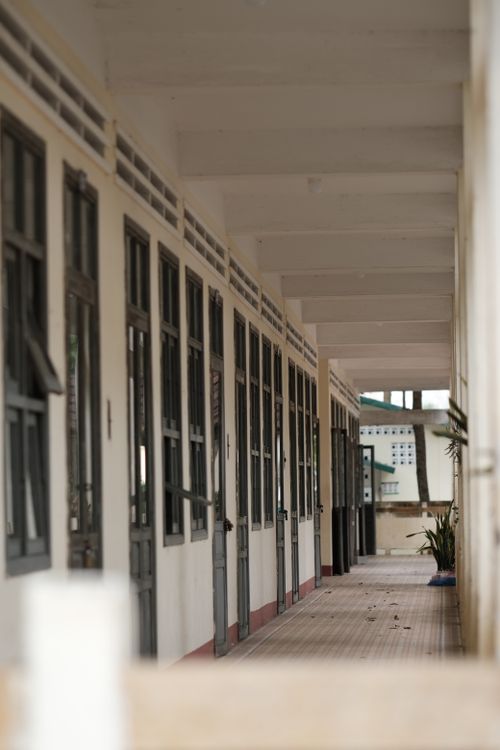 Free Explore the tranquility of an empty corridor in a historic structure, featuring large windows and serene architecture. Stock Photo