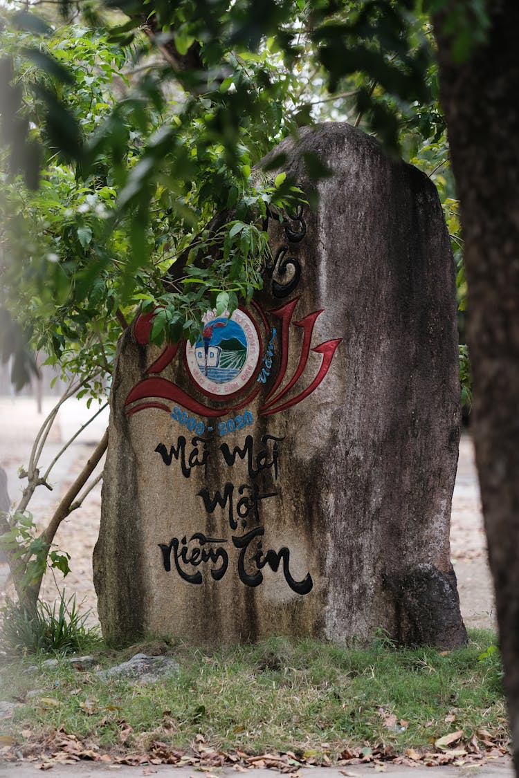 A Rock With A Painting In A Park 