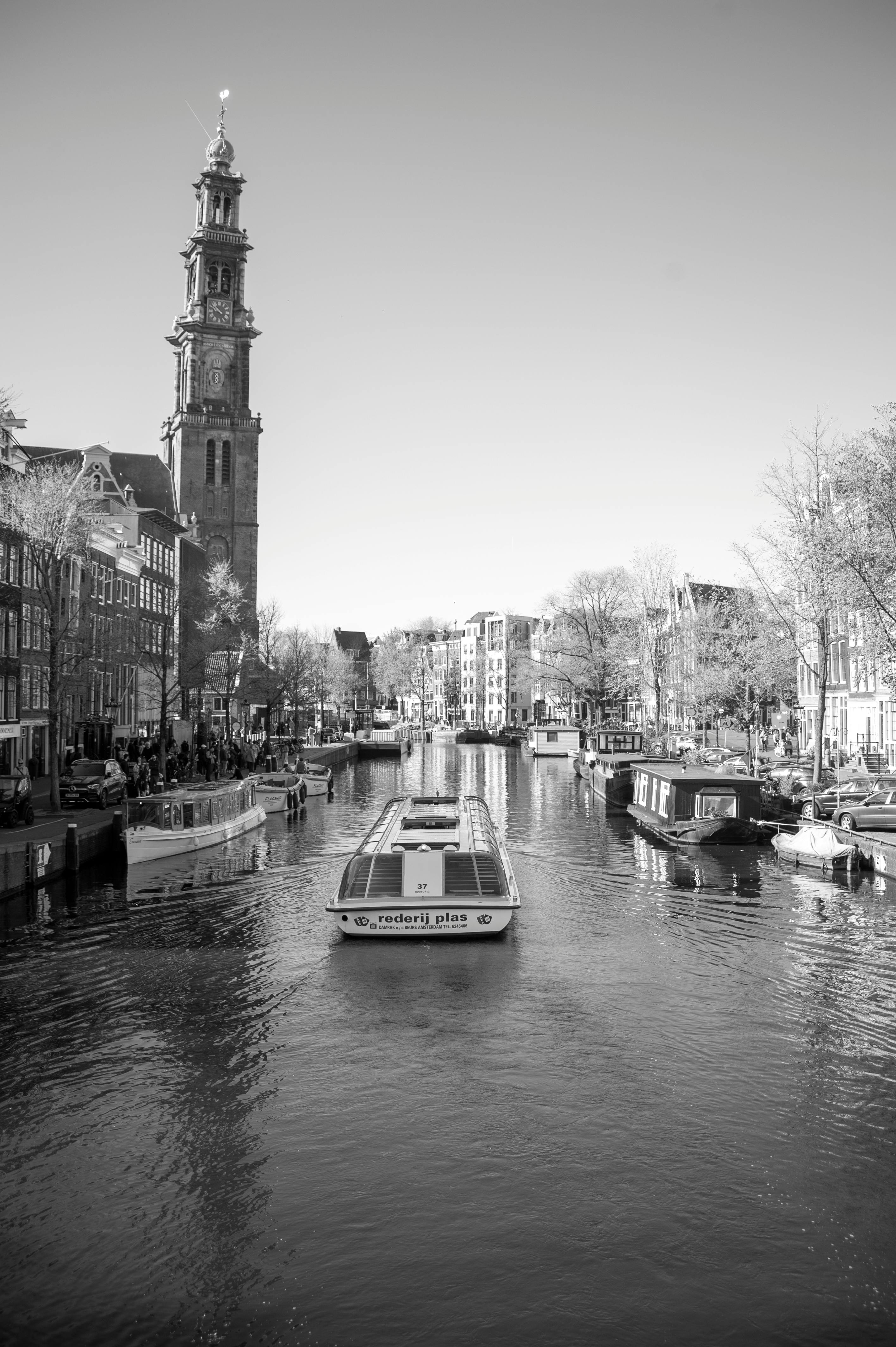 Boat on a calm canal in Amsterdam Netherlands with canal houses