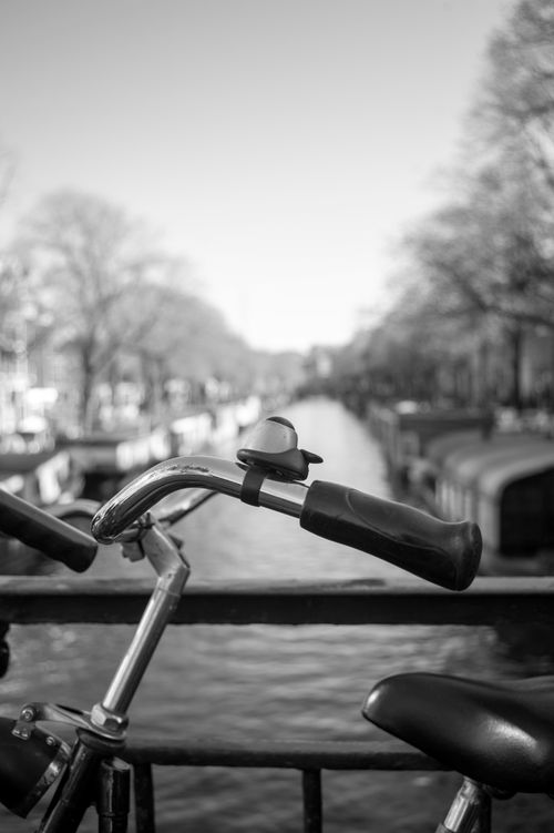 Free Artistic black and white photo of a bicycle in front of a canal on a bridge. Stock Photo