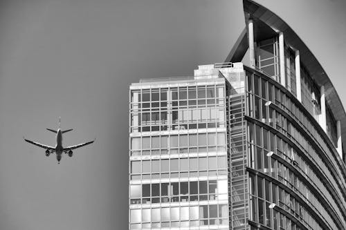 An Airplane Flying near a Skyscraper 