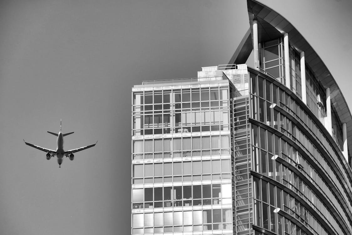 An Airplane Flying near a Skyscraper 