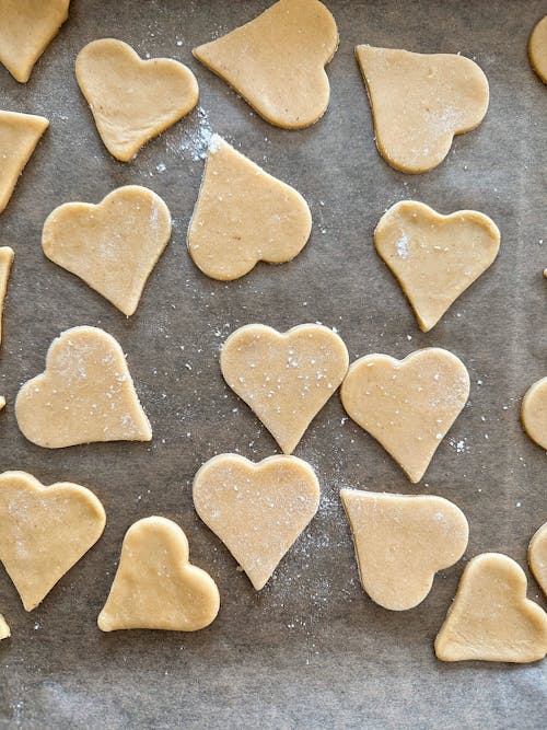 Raw Heart Shaped Cookies on a Tray with Parchment Paper 