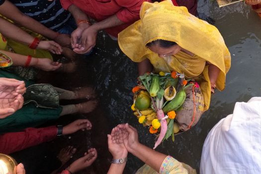Participants perform Chhath Puja rituals in Kolkata, sharing devotional offerings by the river.