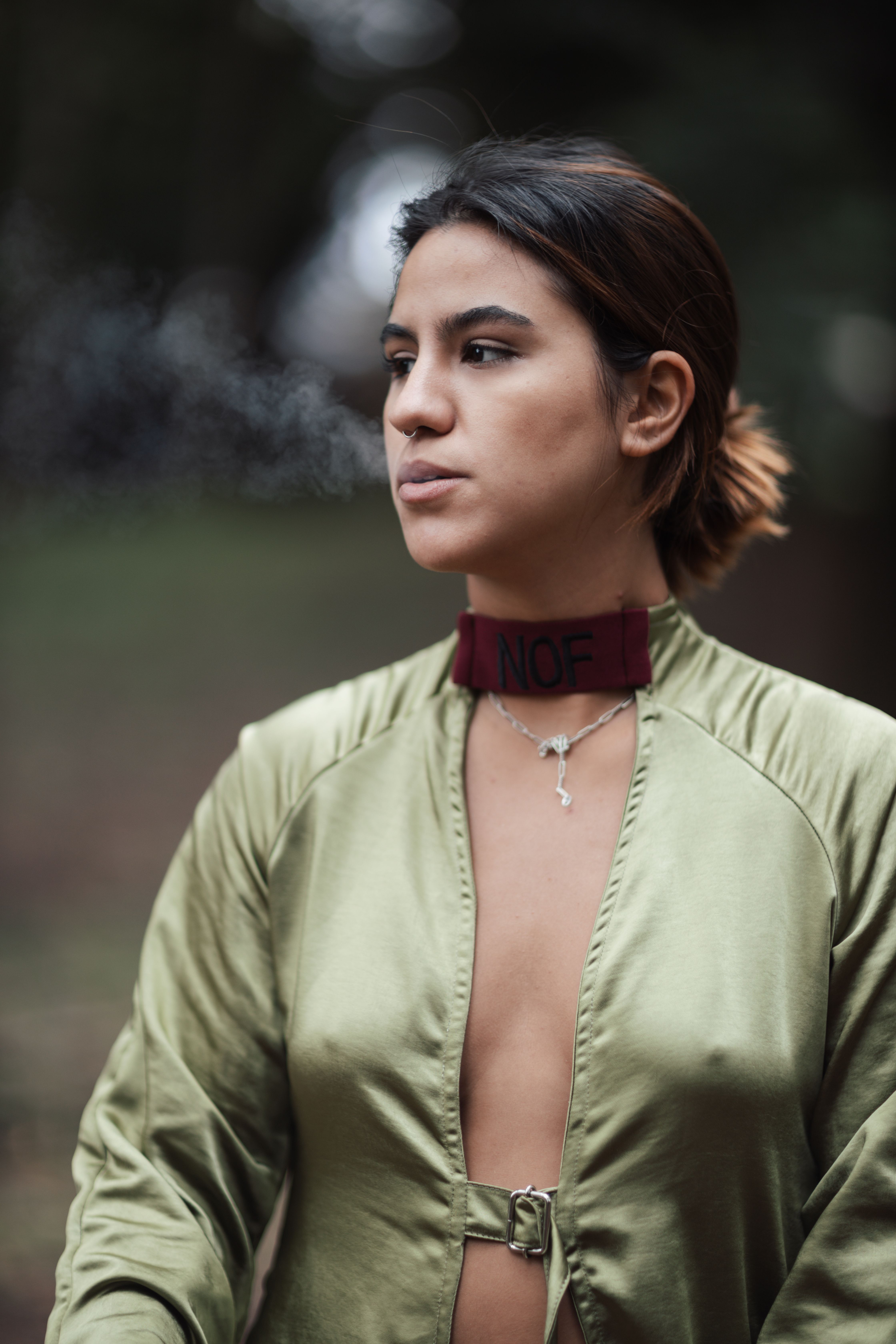 Fashionable woman in a green silk robe with NOF choker. Candid outdoor portrait.