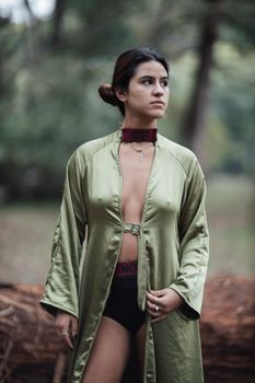 Stylish portrait of a woman in a green coat outdoors, showcasing modern fashion and confidence.