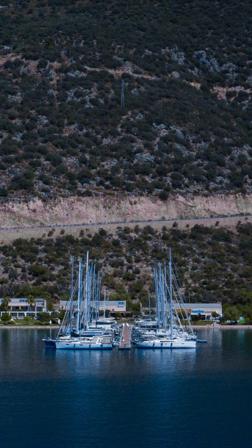 Free Serene view of sailboats moored at a marina in Antalya, Türkiye with mountain backdrop. Stock Photo