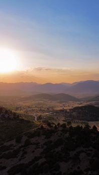 A breathtaking aerial view of a desert valley bathed in golden sunlight during sunrise.