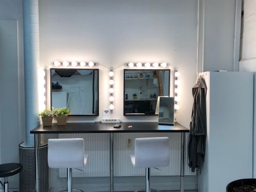 Free Brightly lit vanity station with mirrors and minimalist design, ideal for makeup and styling. Stock Photo