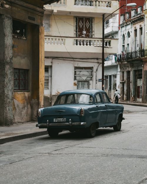 Free Classic retro car parked on an old city street, showcasing vintage urban charm. Stock Photo