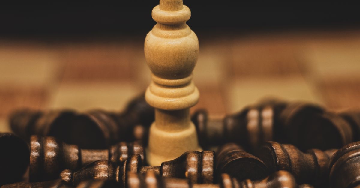 Intriguing close-up of a chess piece surrounded by scattered opponents, highlighting strategy and competition.