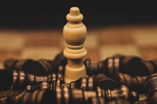 Intriguing close-up of a chess piece surrounded by scattered opponents, highlighting strategy and competition.