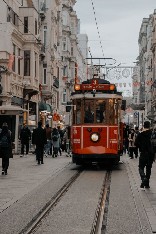 Free Red tram moving along bustling Istiklal Avenue in Istanbul, Turkey with pedestrians. Stock Photo