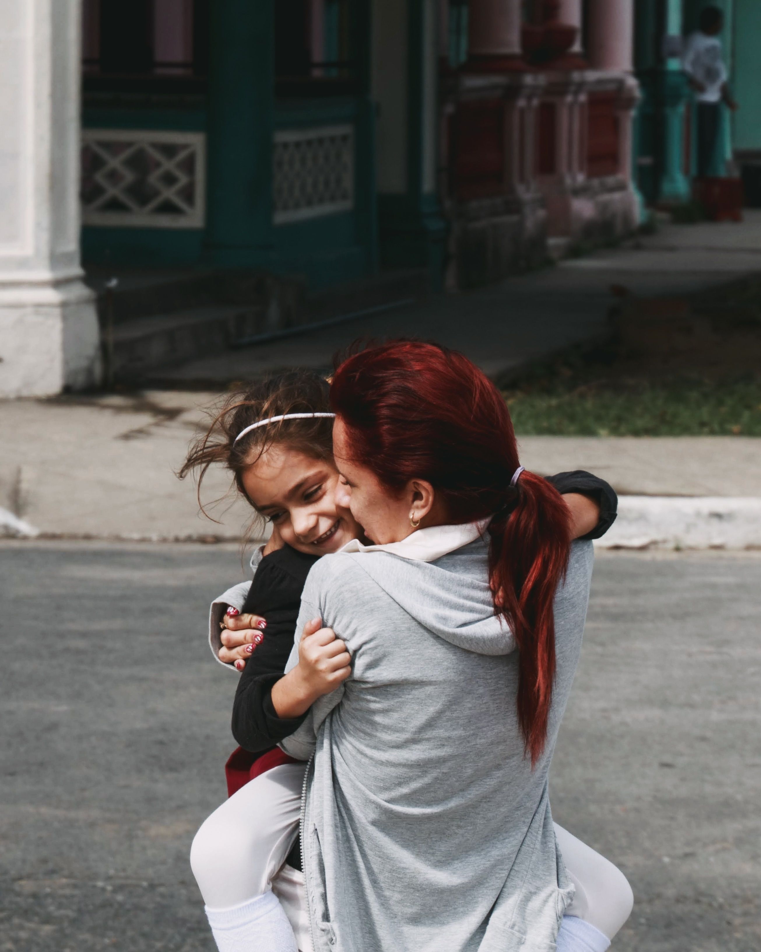 Woman Hugging Her Daughter on a Street · Free Stock Photo