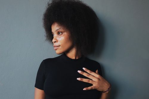 Free Side profile of a woman with afro hair against a gray background, exuding elegance and confidence. Stock Photo