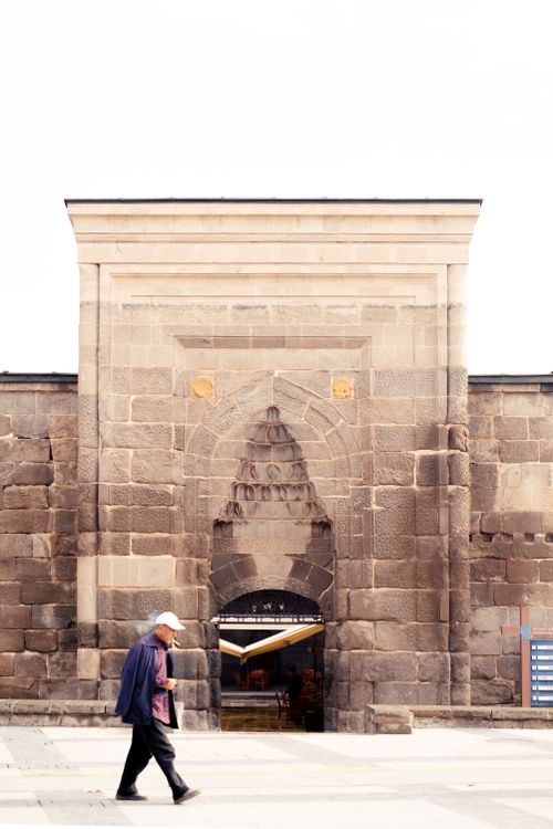 Free Man walking past the historic Hunat Hatun Complex in Kayseri, Türkiye. Stock Photo