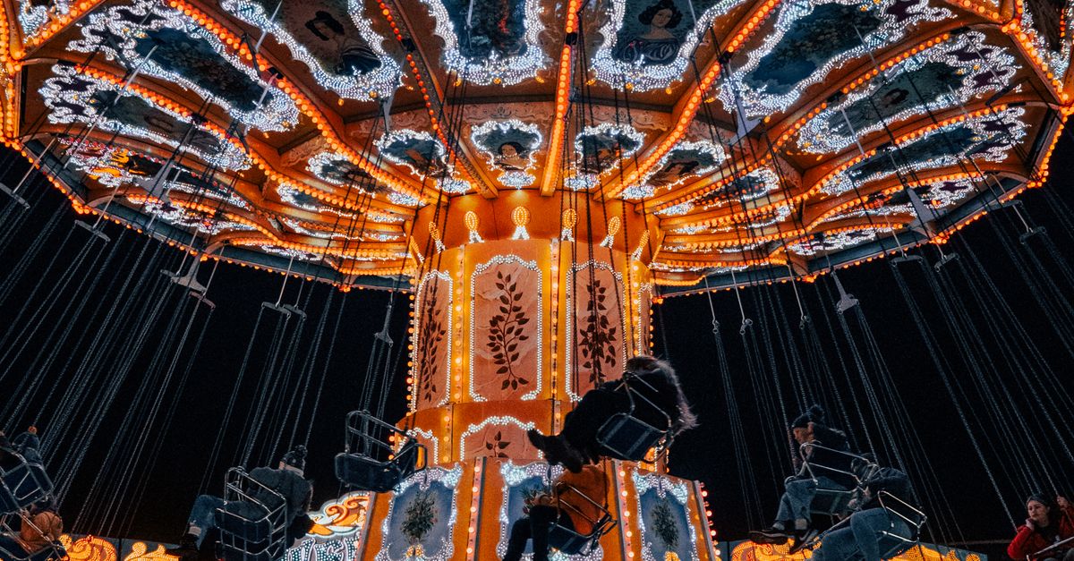 Illuminated Wave Swinger Carousel on a Christmas Market · Free Stock Photo