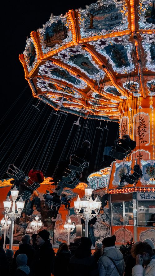 Free Vibrant night view of a lit carousel swing ride at a fairground in Hamburg, Germany. Stock Photo