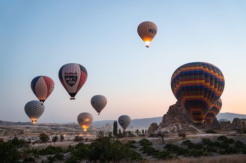 Free Captivating view of hot air balloons soaring over Cappadocia's unique landscape at sunrise in Türkiye. Stock Photo