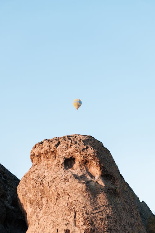 A Rock Formation and a Flying Hot Air Balloon 