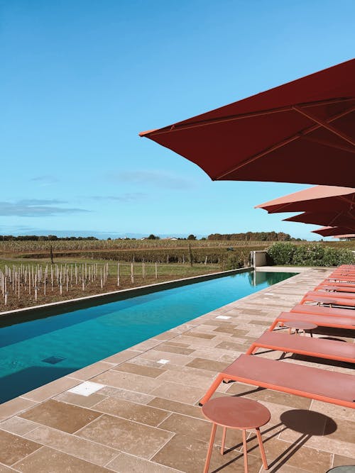 Loungers by Swimming Pool with View on Field