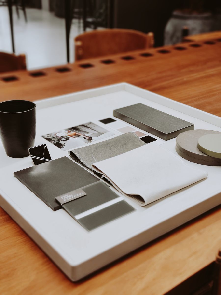 Interior material samples, timber swatches and colour cards laid out on a desk