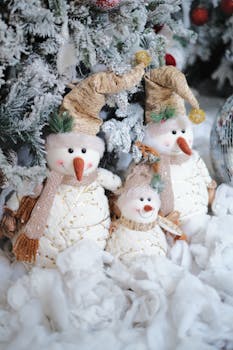 Charming snowmen decorations in a winter setting, ideal for holiday themes.
