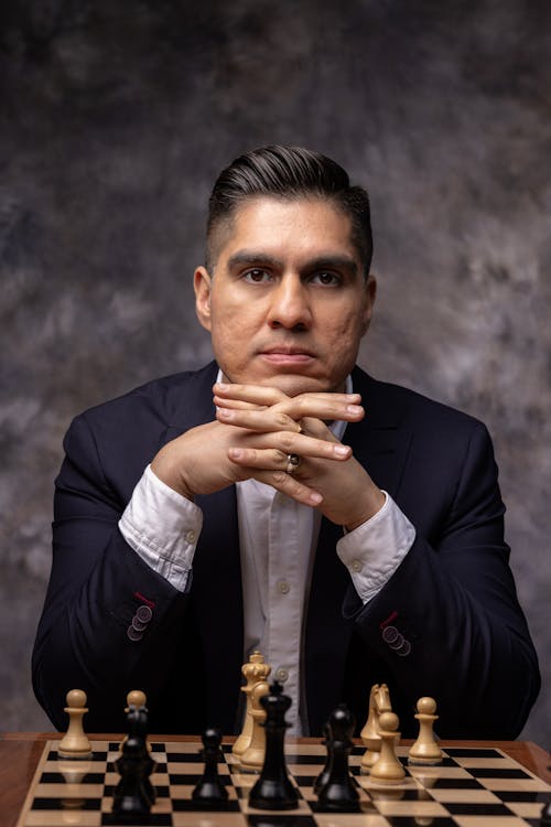 Man in Suit Sitting by Chess