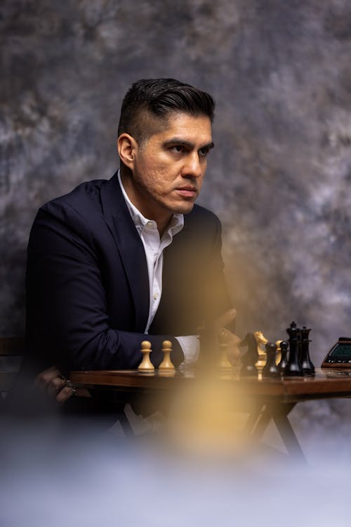 Man in Suit Playing Chess